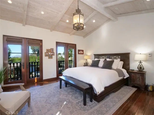 a spacious bedroom with a bed and a chandelier