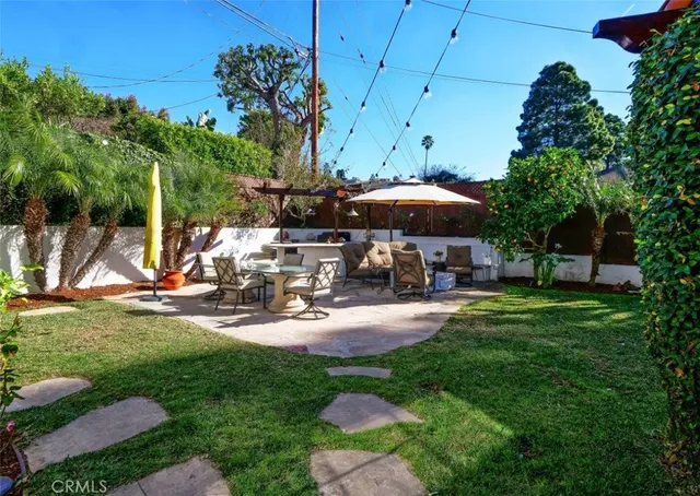 a view of a backyard with table and chairs under an umbrella