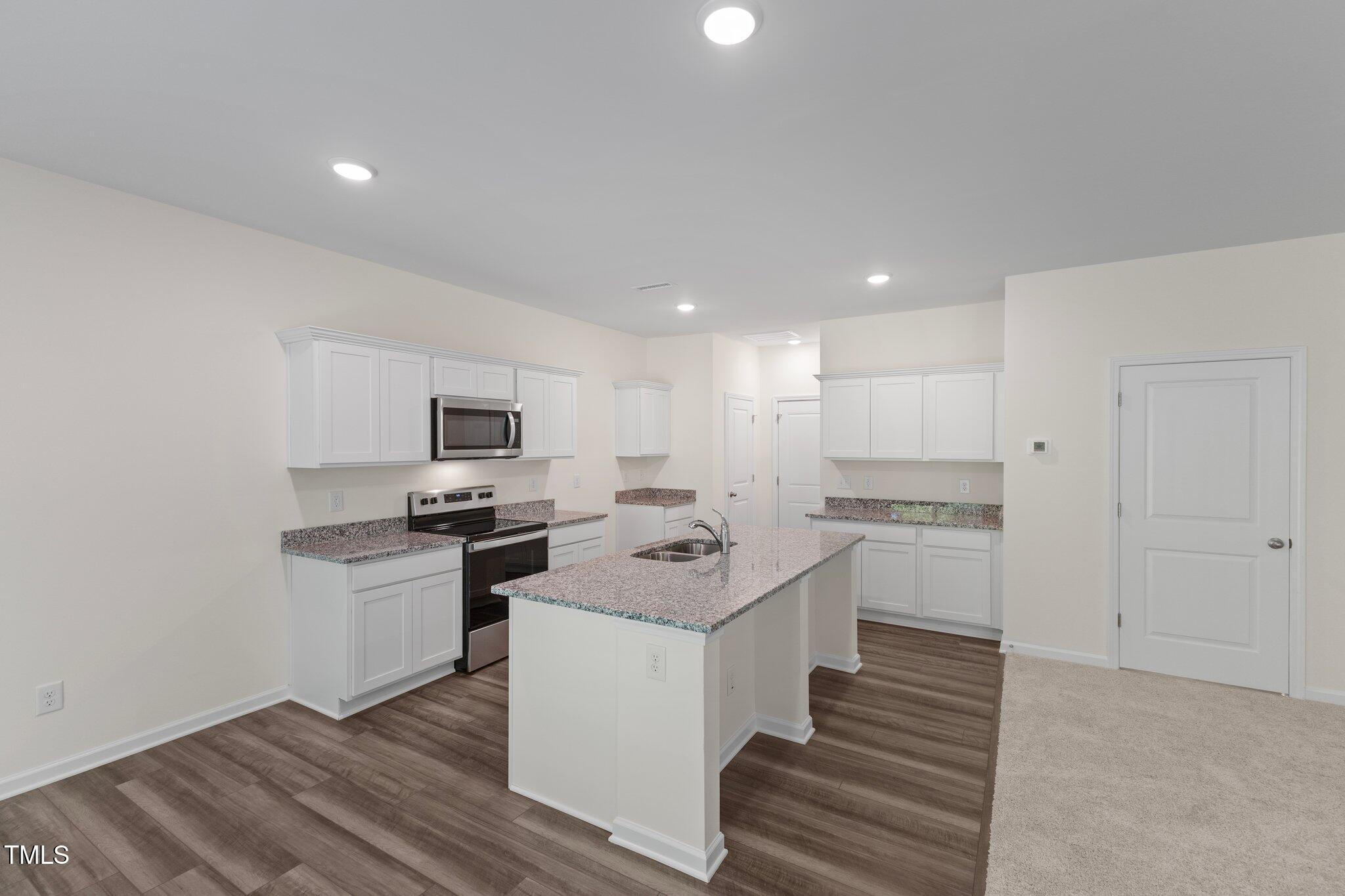 1200 Solace Way Rolesville, NC 27571 - Photo 6 of 24 a kitchen with stainless steel appliances granite countertop a sink stove and refrigerator