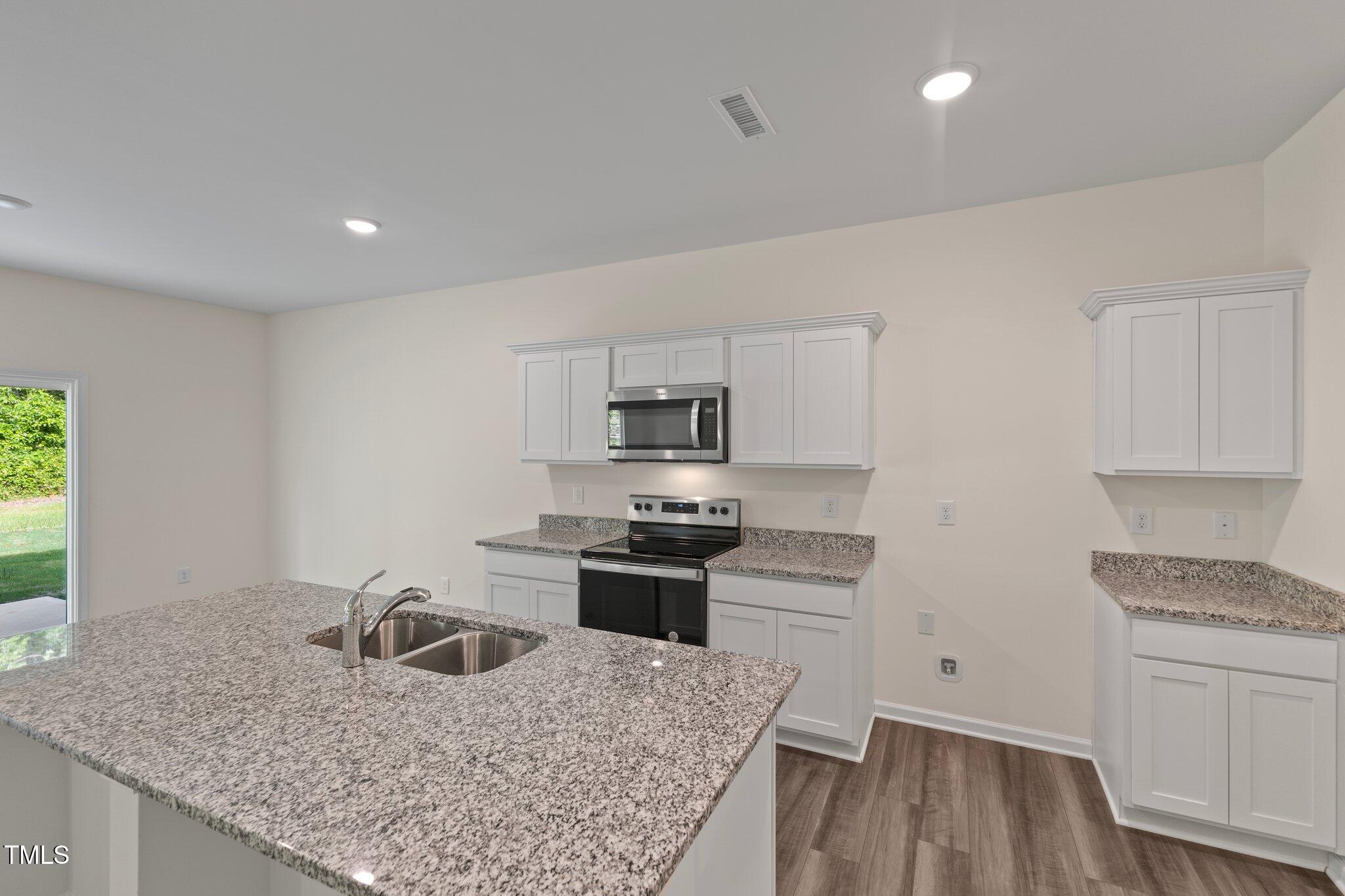 1200 Solace Way Rolesville, NC 27571 - Photo 7 of 24 a kitchen with stainless steel appliances granite countertop a sink stove and refrigerator