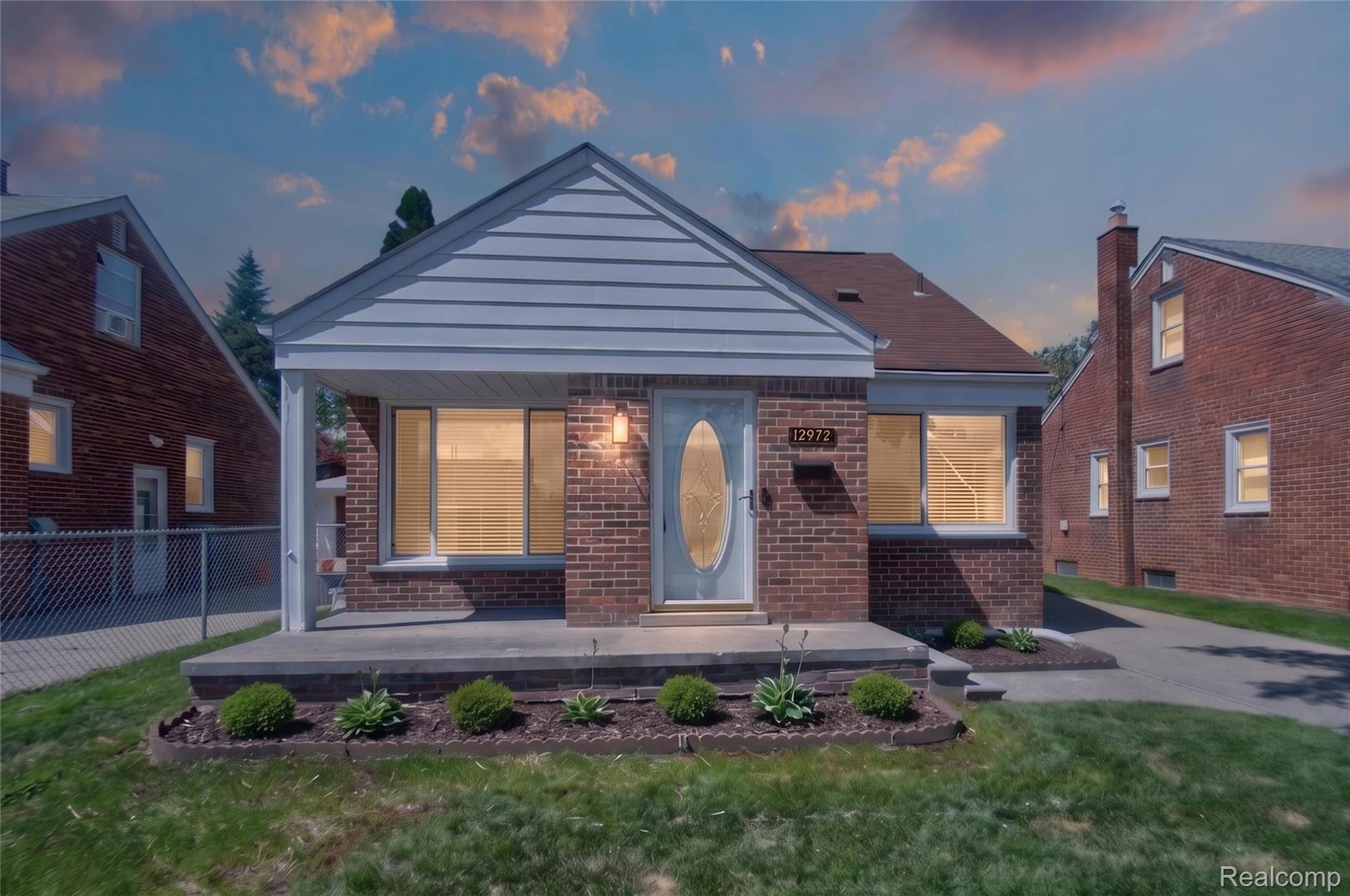 12972 Callender Street Southgate, MI 48195 - Photo 2 of 40 Brick facade home featuring a covered front porch, white siding gable, landscaping with shrubs, and a paved driveway