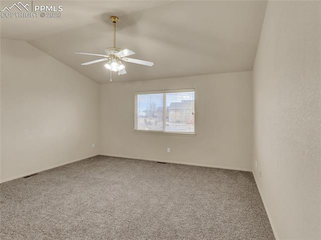 8599 Tibbs Road Peyton, CO 80831 - Photo 17 of 38 Master bedroom with new carpeting! Vaulted ceiling and ceiling fan make this the perfect master bedroom retreat!