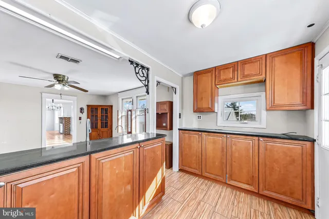 a kitchen with stainless steel appliances granite countertop wooden cabinets a stove and a sink