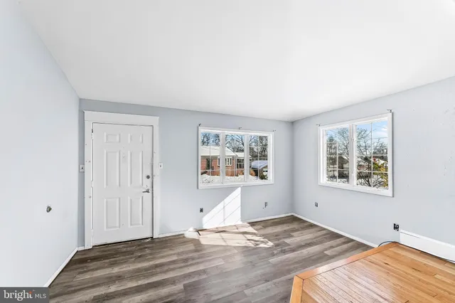 a view of a bedroom with wooden floor and window