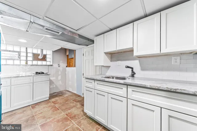a kitchen with kitchen island granite countertop white cabinets white stainless steel appliances with a sink and dishwasher