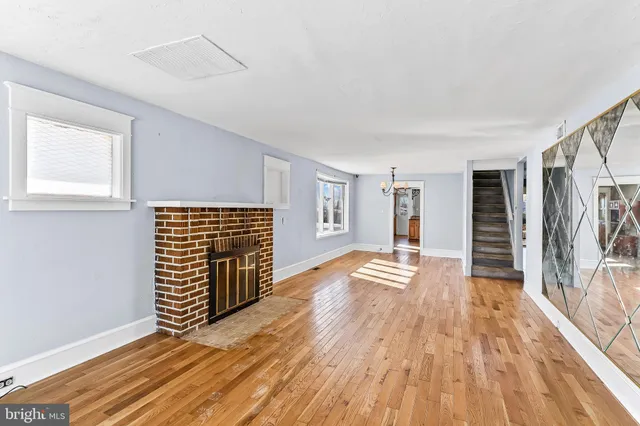 a view of empty room with wooden floor and stairs