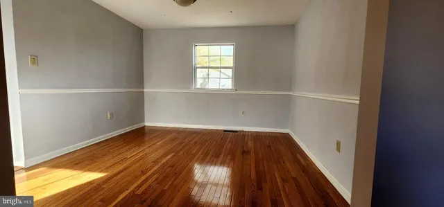 a view of a room with wooden floor and window