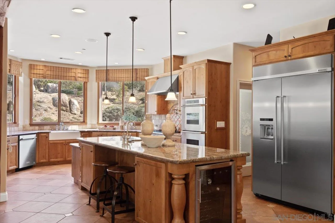 11760 Betsworth Road Valley Center, CA 92082 - Photo 11 of 47 a kitchen with stainless steel appliances granite countertop a sink and a refrigerator