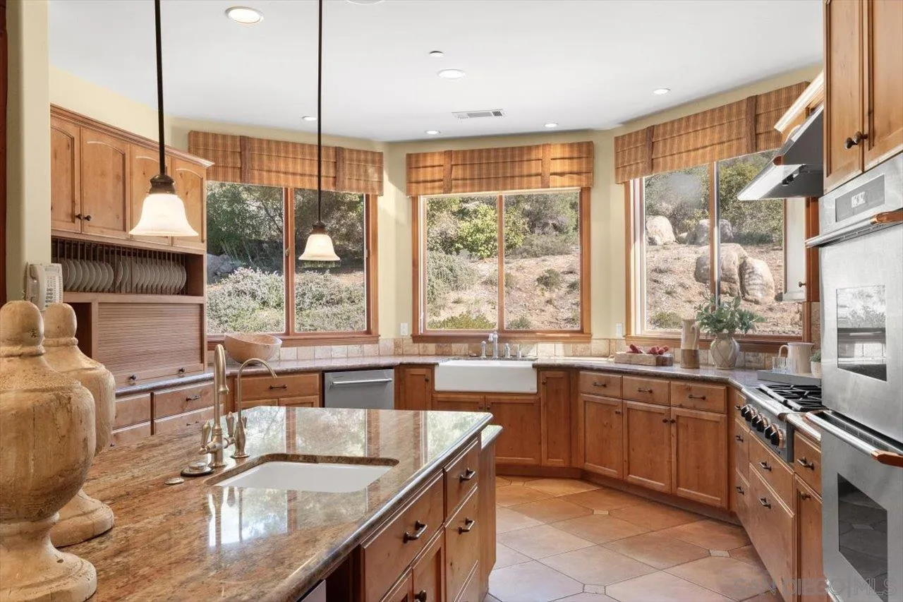 11760 Betsworth Road Valley Center, CA 92082 - Photo 12 of 47 a kitchen with kitchen island granite countertop a sink and a counter top space