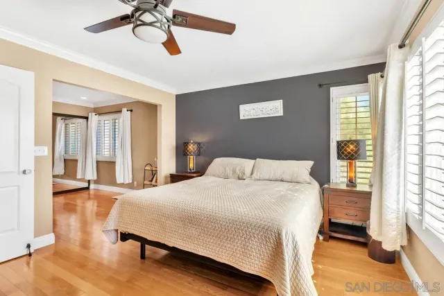 a bedroom with a bed a dresser and a chandelier