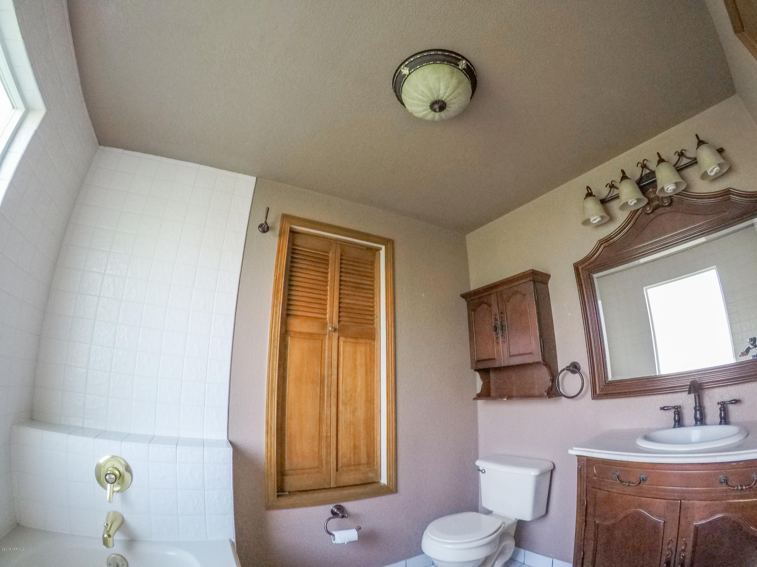 13406 Summitview Ext Road Yakima, WA 98908 - Photo 23 of 26 a bathroom with a granite countertop sink and a mirror next to a window