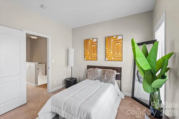 a bedroom with a bed a potted plant and a window