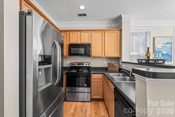 a kitchen with stainless steel appliances a sink cabinets and a window