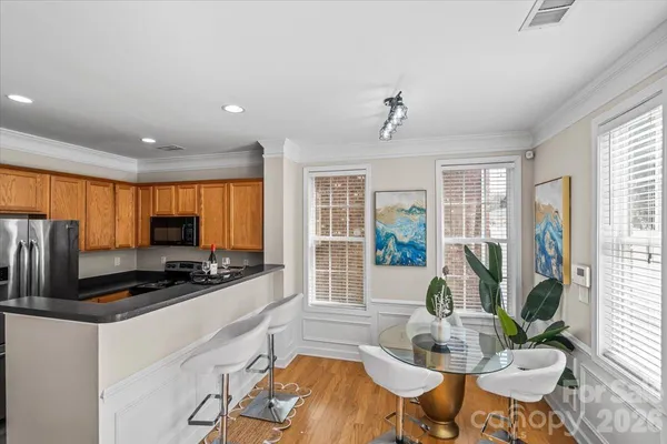 a kitchen with sink refrigerator dining table and chairs