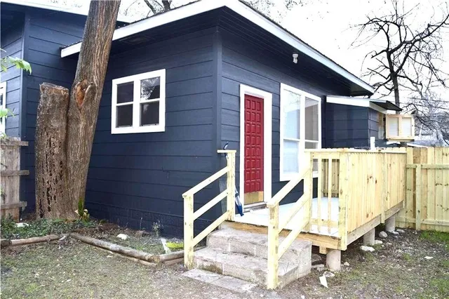 a view of a house with a yard and wooden fence