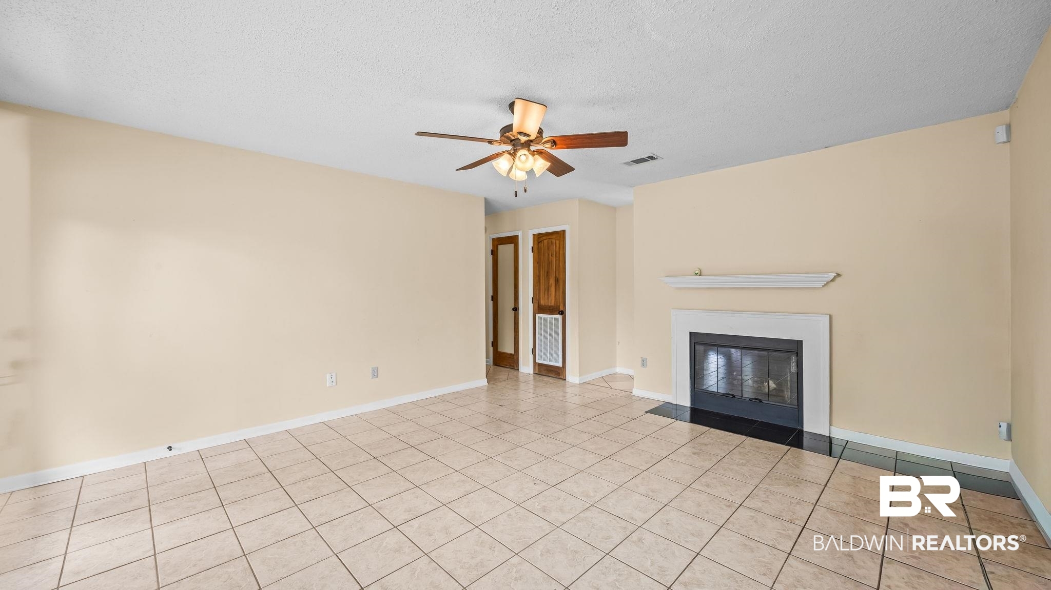 15096 Highland Circle Foley, AL 36535 - Photo 12 of 52 Spacious living area featuring neutral-toned walls, tile flooring, and a ceiling fan with integrated lighting