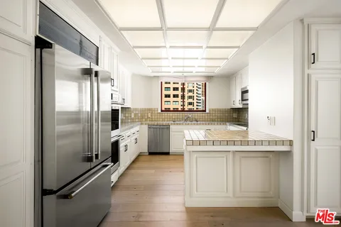 a kitchen with white cabinets and appliances