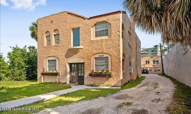 a front view of a house with a garden and plants