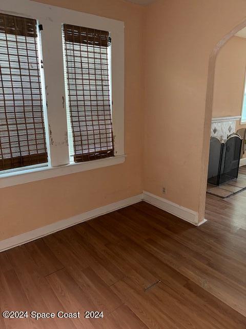 1219 East Strawbridge Avenue, Unit 4 Melbourne, FL 32901 - Photo 8 of 9 an empty room with wooden floor and windows