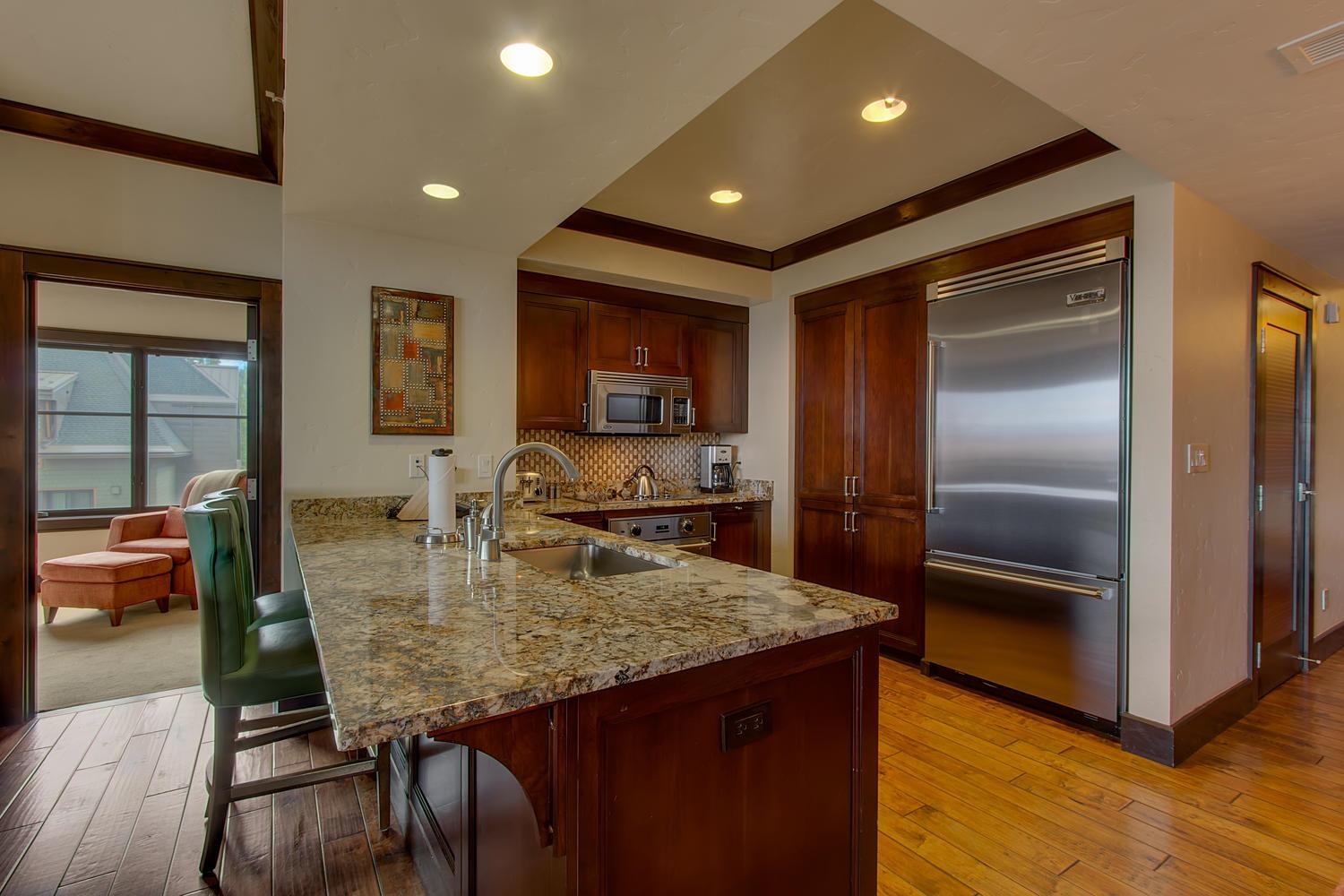 13051 Ritz Carlton Highlands Court, Unit 4308 INTEREST 8 Truckee, CA 96161 - Photo 15 of 26 a kitchen with granite countertop kitchen island a refrigerator a stove a dining table and chairs with wooden floor