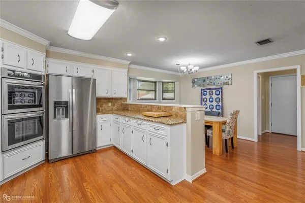 a kitchen with granite countertop a refrigerator and a stove top oven