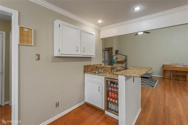 a view of a kitchen with sink and wooden floor