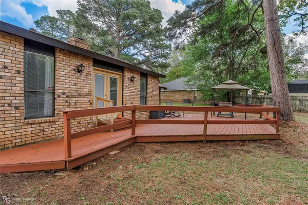 a view of backyard with deck and outdoor seating