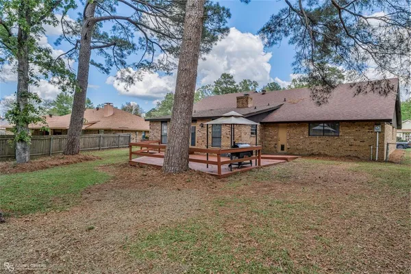 a view of house with backyard and outdoor seating