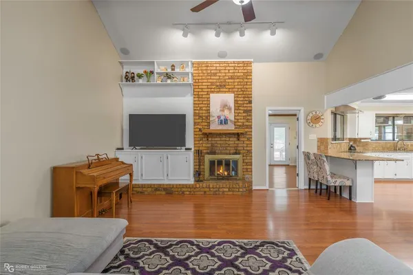 a living room with furniture a flat screen tv and kitchen view