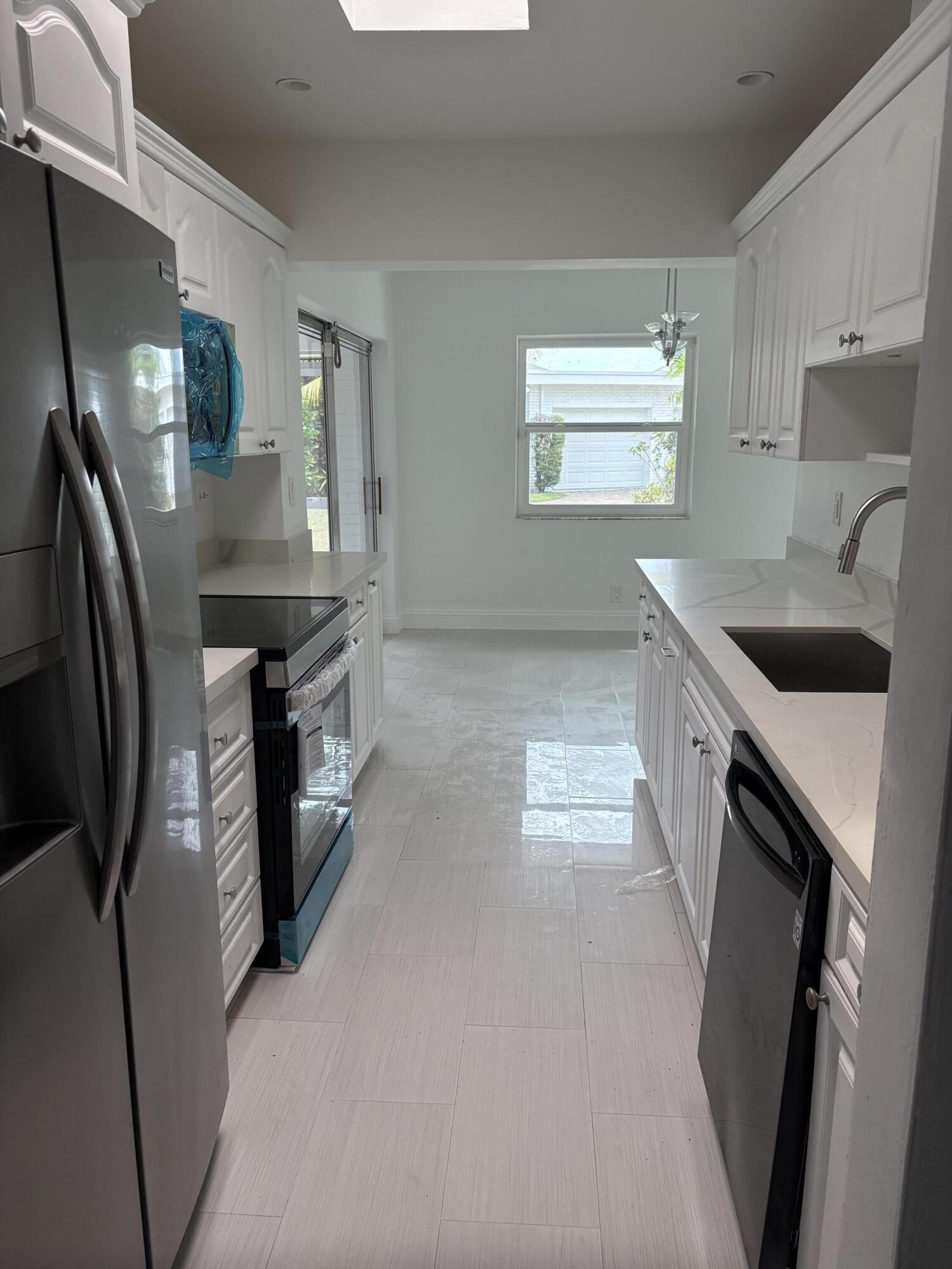 5904 Cedar Circle Tamarac, FL 33319 - Photo 7 of 23 a kitchen with stainless steel appliances granite countertop a sink a stove a washer and dryer