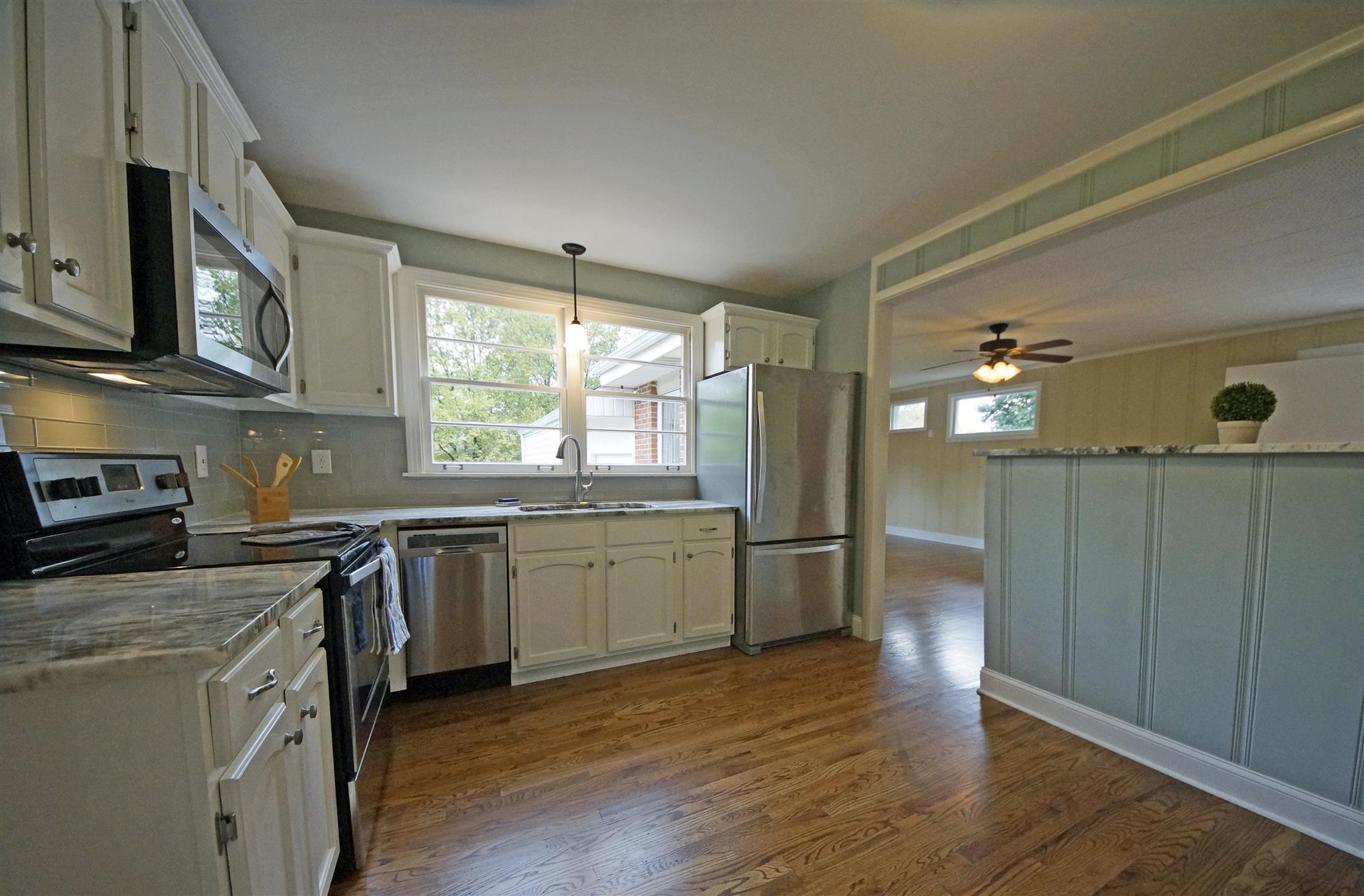 807 River Pass Madison, TN 37115 - Photo 8 of 25 a kitchen with granite countertop a stove top oven a sink dishwasher and a refrigerator with wooden floor