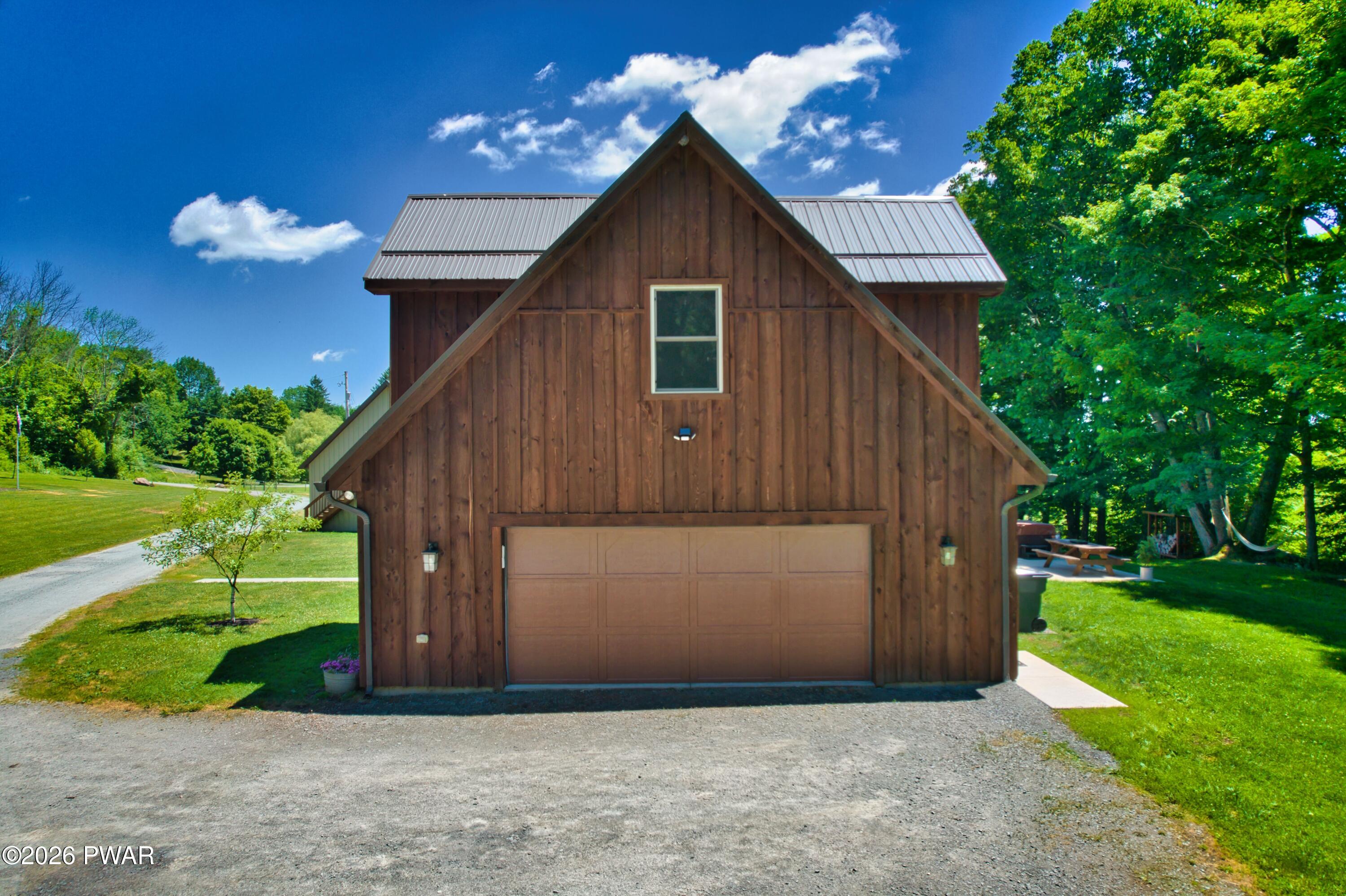149 Sheards Road Milanville, PA 18443 - Photo 7 of 57 a view of a small house in front of a big yard with plants and large trees