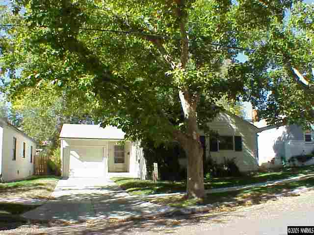 a front view of a house with a yard and trees