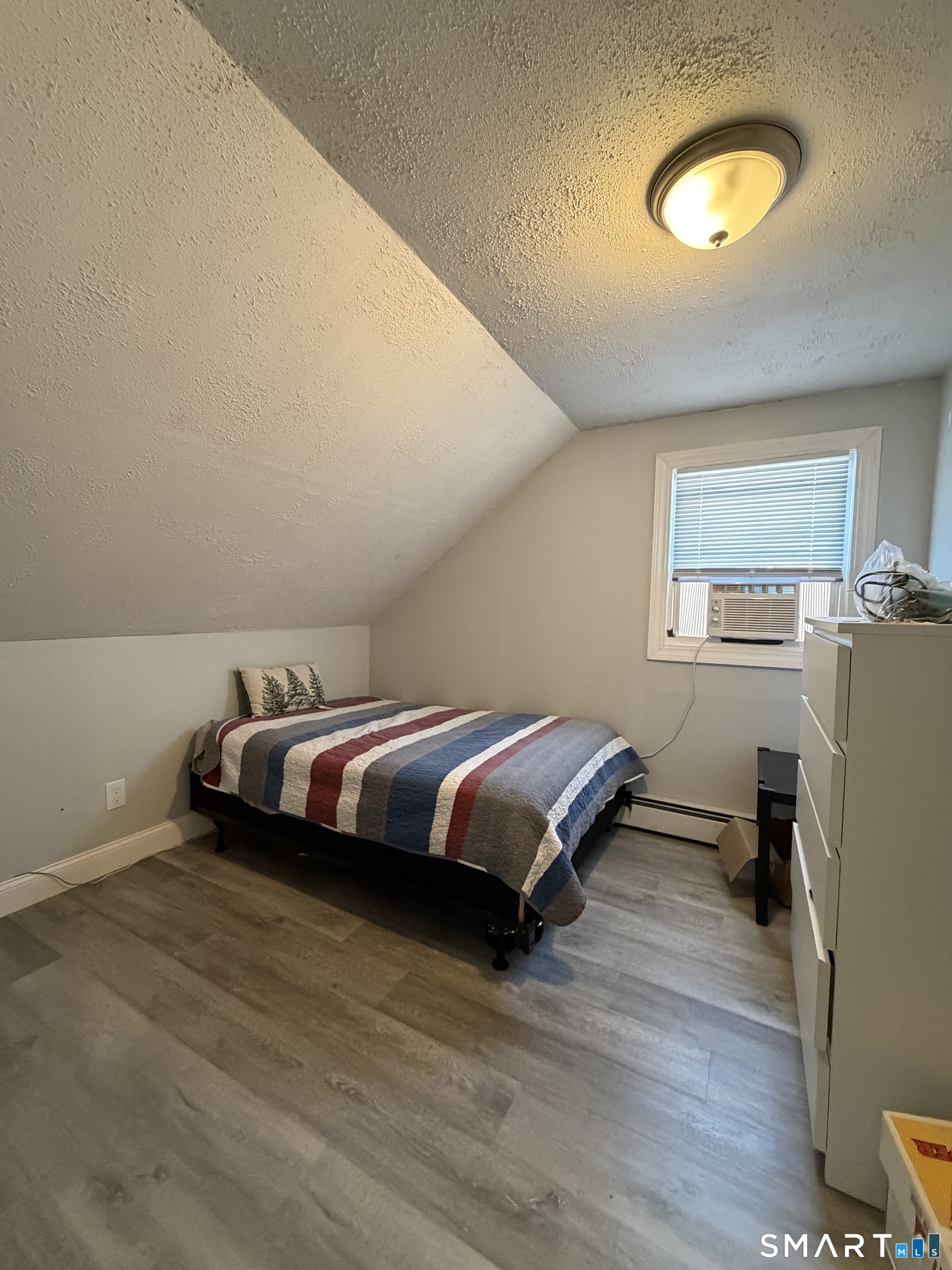 19 Maple Street Plainville, CT 06062 - Photo 19 of 25 a bedroom with a bed and wooden floor