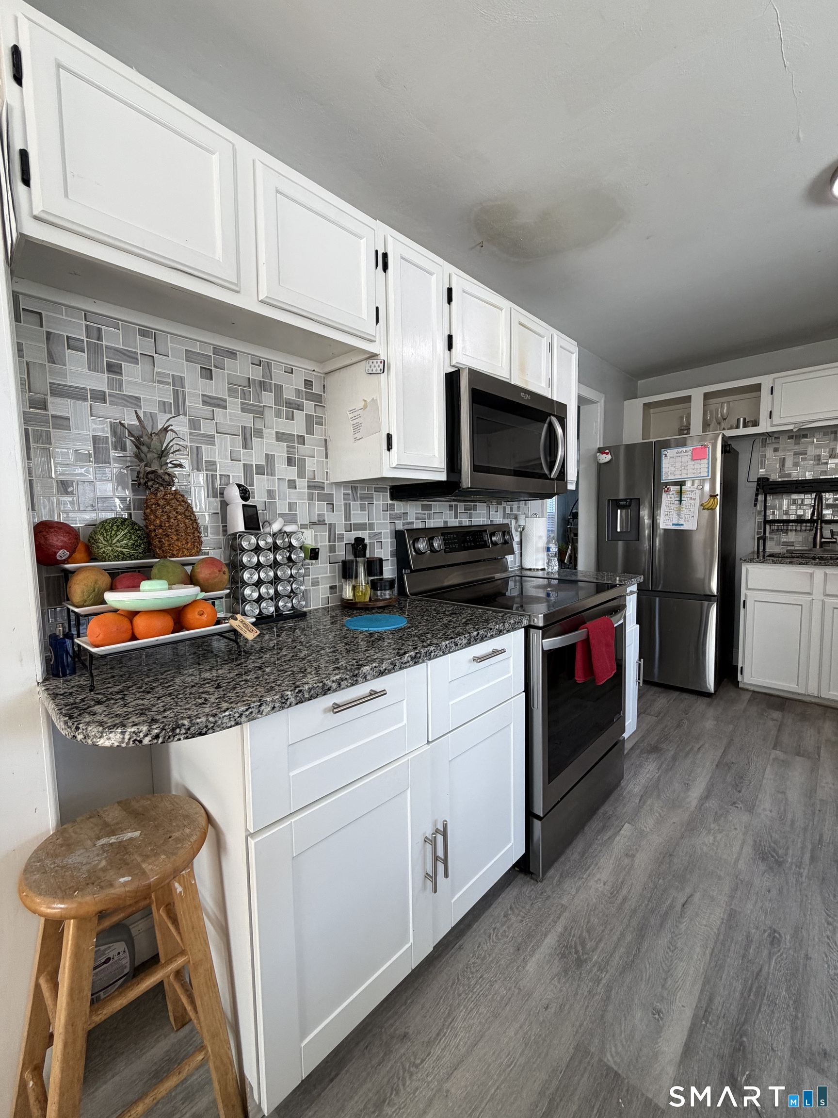 19 Maple Street Plainville, CT 06062 - Photo 7 of 25 a kitchen with stainless steel appliances kitchen island granite countertop a stove and a microwave
