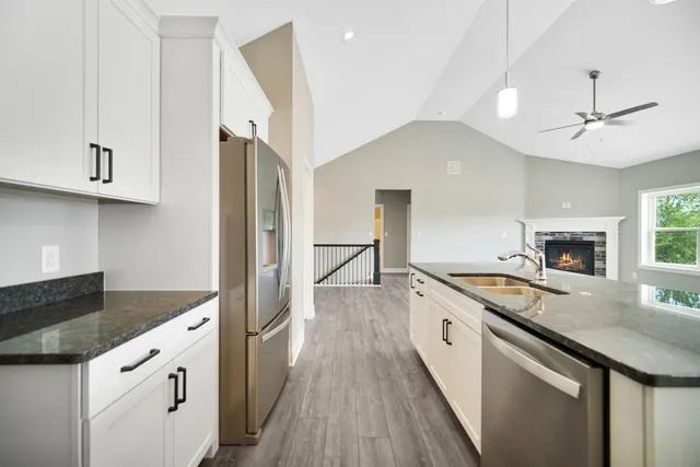 a kitchen with granite countertop a sink stove and refrigerator
