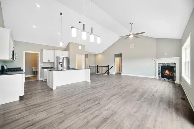 a view of a kitchen and a livingroom with fireplace wooden floor windows