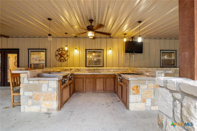 a large kitchen with stainless steel appliances a stove a sink dishwasher a dining table and chairs with wooden floor