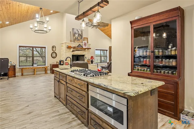 a kitchen with stainless steel appliances kitchen island granite countertop a refrigerator and a sink