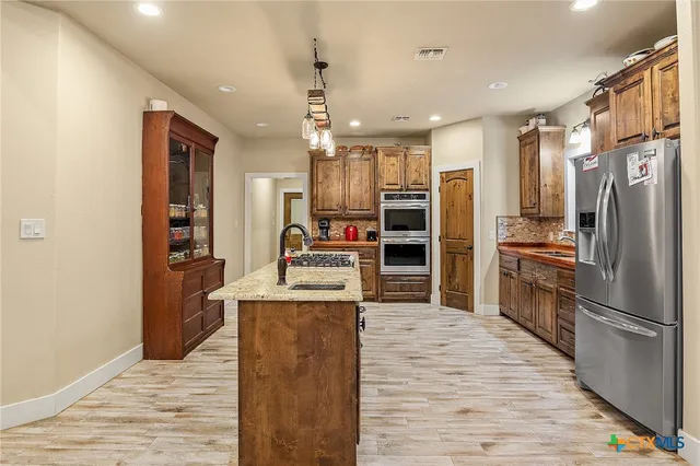 a kitchen with stainless steel appliances granite countertop a stove and a refrigerator