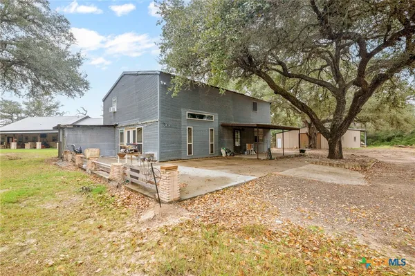 a view of a house with backyard and trees