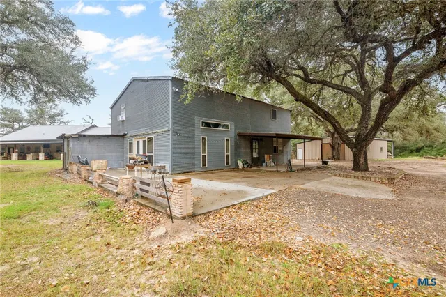 a view of a house with backyard and trees