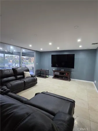 a large hall with stainless steel appliances granite countertop a couch and cabinets