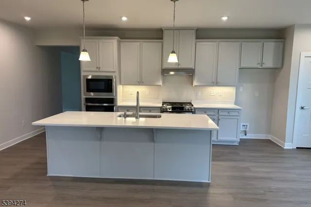 a kitchen with kitchen island a sink stainless steel appliances and cabinets