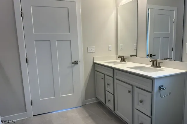 a bathroom with a double vanity sink and a mirror