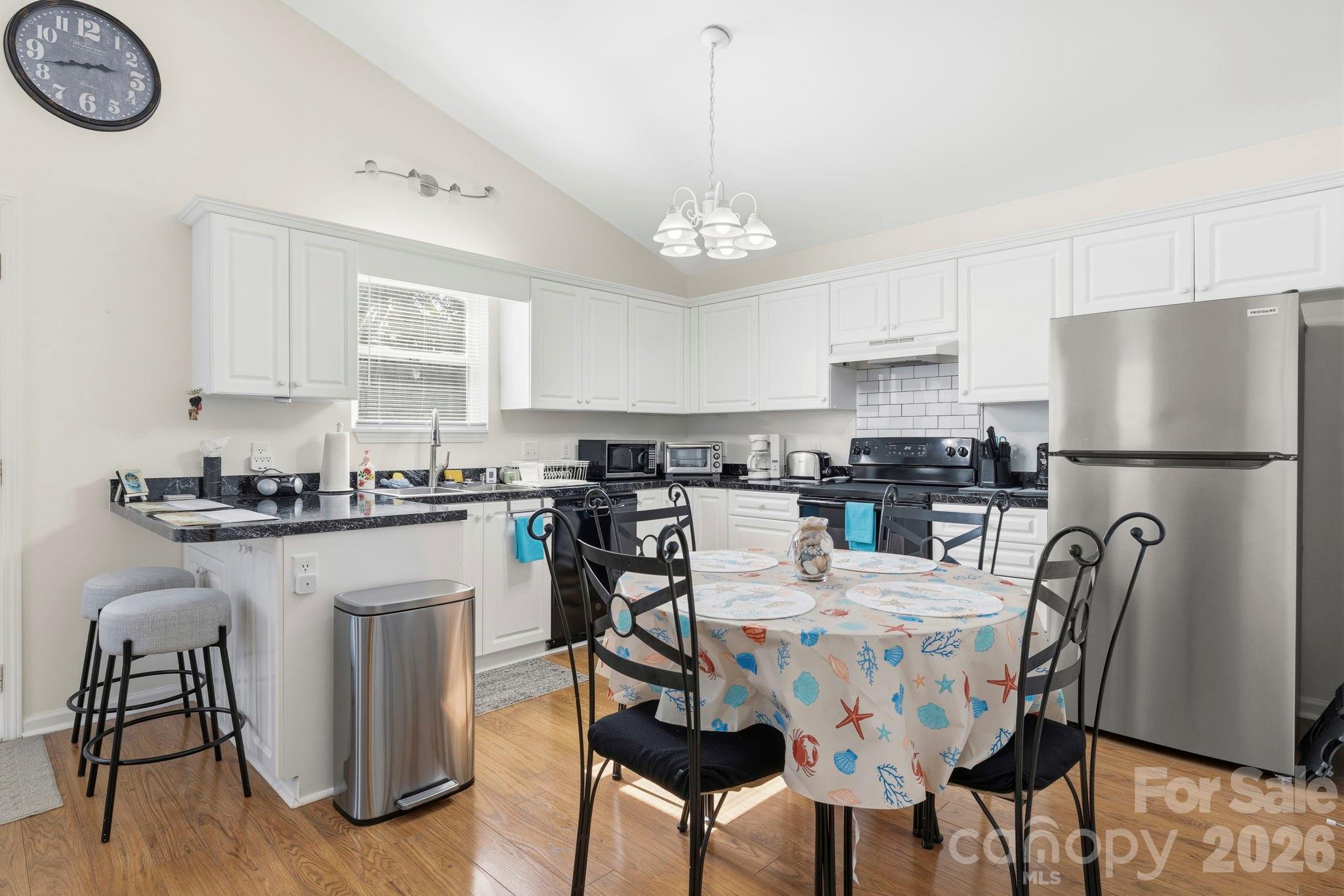1539 Schooner Court Murrells Inlet, SC 29576 - Photo 6 of 28 a kitchen with stainless steel appliances granite countertop a dining table chairs refrigerator and cabinets