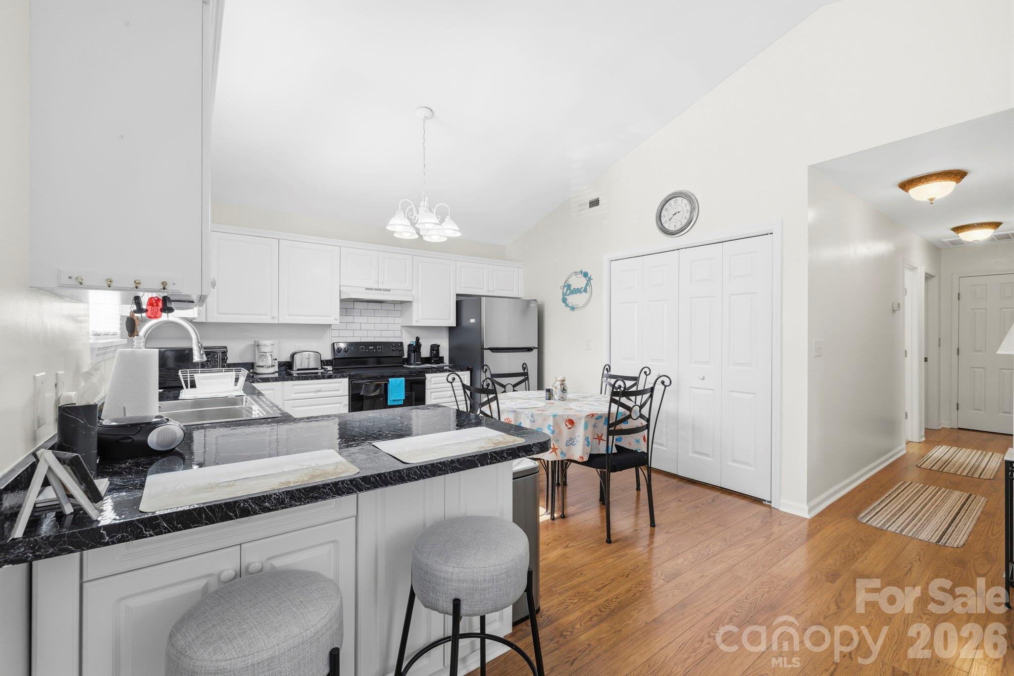 1539 Schooner Court Murrells Inlet, SC 29576 - Photo 7 of 28 a kitchen with stainless steel appliances granite countertop a table chairs refrigerator and sink