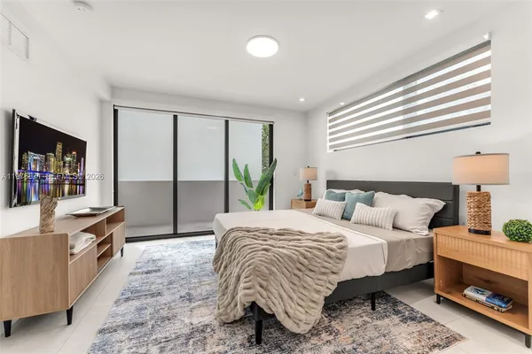 a bedroom with a bed a dresser and next to a window