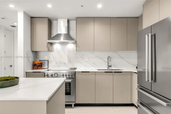 a kitchen with stainless steel appliances granite countertop a sink a stove and a refrigerator