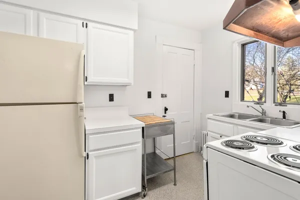 a kitchen with a refrigerator sink stove and cabinets